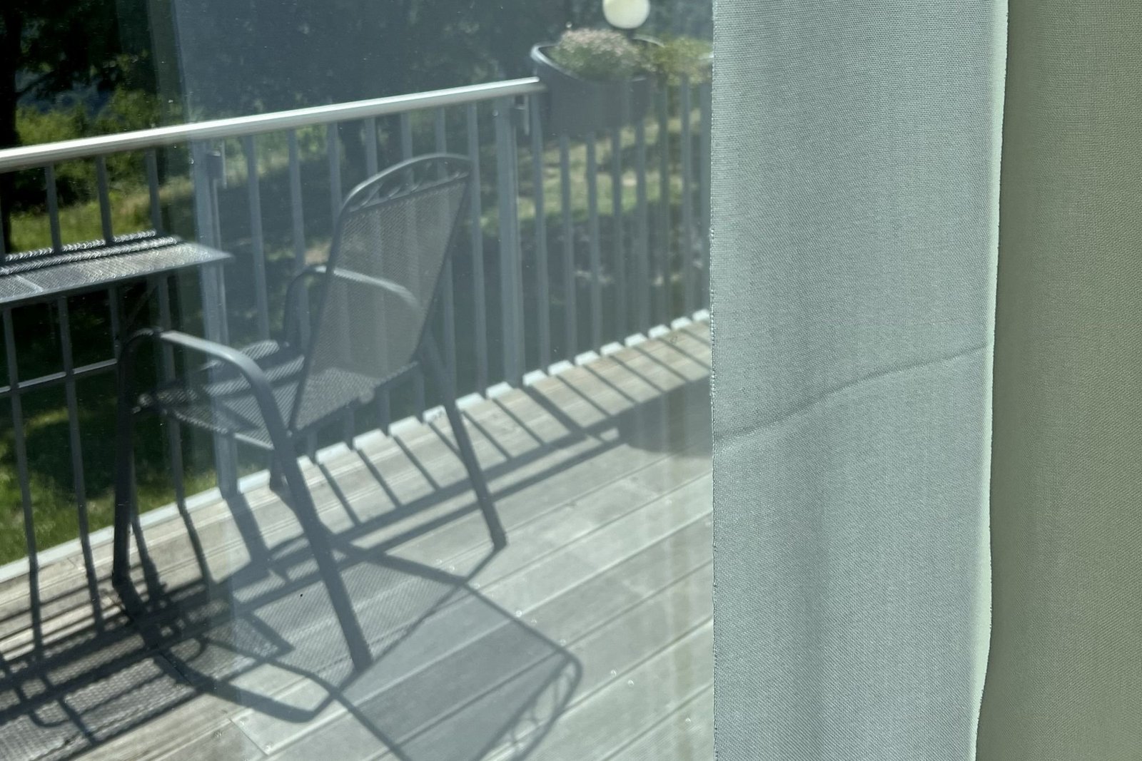 Blick aus dem Zimmer auf Balkon mit Stuhl